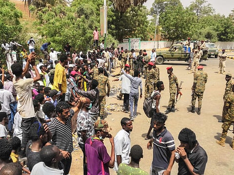 Sudanese soldiers monitor a rally in front of the military headquarters in Khartoum. Thousands have been camping outside the complex housing Al Bashir’s official residence.