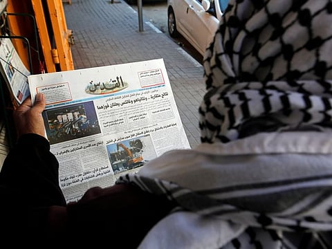 A Palestinian man catches up on election news in Hebron.
