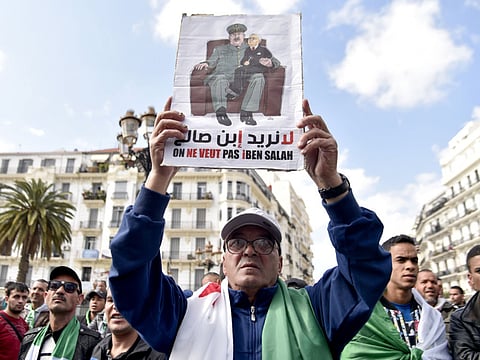An Algerian protester raises a placard as he takes part in a demonstration in the capital Algiers.