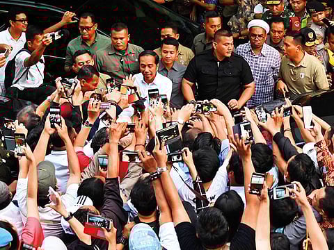 Indonesian President Joko Widodo (C) greets supporters after the country's general election in Jakarta on April 17, 2019.