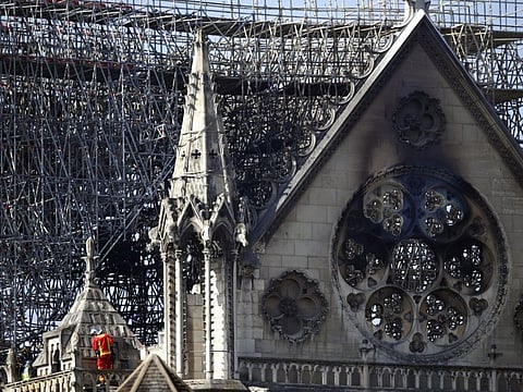 A fire fighter makes his way on a balcony of Notre Dame cathedral Wednesday, April 17, 2019 in Paris.