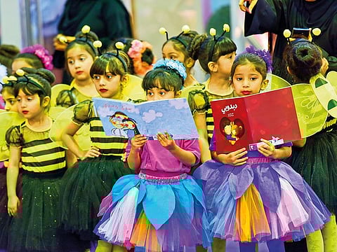 Little girls busy reading story books.