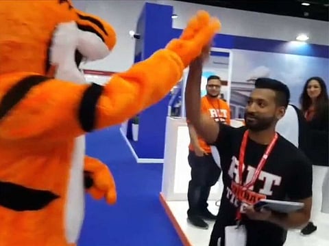 A student-volunteer wearing a university mascot high-fives a visitor at Dubai’s Getex university fair on Wednesday.