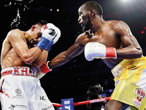 Terence Crawford (right) punches Amir Khan during the fourth-round in New York on Sunday.