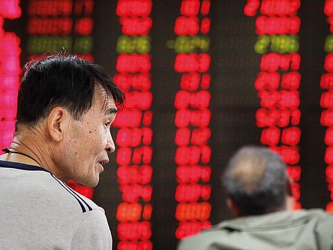 Investors monitor stock prices at a brokerage house in Beijing.