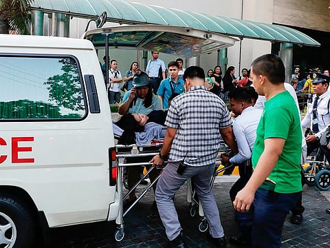 Rescue workers carry a woman to an ambulance after she became dizzy following an earthquake hit Manila, on Monday, April 22, 2019.