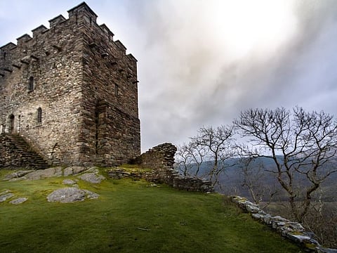 Magnificent moody sunset view of the tower of the crumbling ruins of Dolwyddelan in Snowdonia National Park, Wales UK.