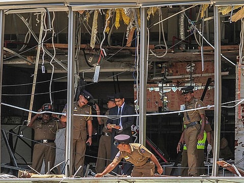 a Sri Lankan Police officer inspects a blast spot at the Shangri-la hotel in Colombo, Sri Lanka. Sri Lankan authorities blame seven suicide bombers of a domestic militant group for coordinated Easter bombings that ripped through Sri Lankan churches and luxury hotels