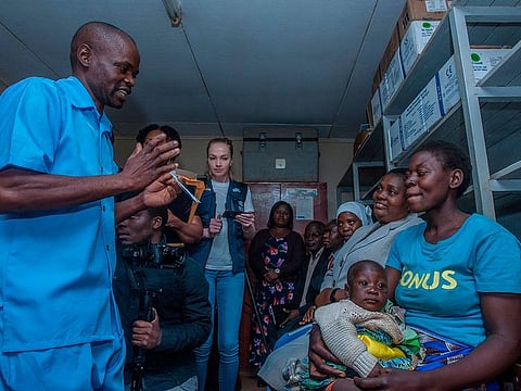 A Health Surveilance Assistant (HAS) civic educates a mother (R) before giving her child a dose of Malaria Vaccine as Expanded Programme for Immunization Programme Manager Temwe Mzengeza (2nd R), and Hanifa Likaka (3rd R), Senior Nursing Officer and Matron for the vaccine launch venue hospital, look on on April 23, 2019 at Mitundu Community hospital in Malawi's capital district of Lilongwe on the first day of the Malaria vaccine implementation pilot programme in Malawi aiming to immunise 120,000 children aged two years and under to assess the effectiveness of the pilot vaccine and whether the delivery process is feasible. Malawi spearhead today large scale pilot tests for the world's most advanced experimental malaria vaccine in a bid to prevent the disease that kills hundreds of thousands across Africa each year. After more than three decades in development and almost $1 billion in investment, the cutting-edge trial will be rolled out in Malawi's capital Lilongwe this week and then in Kenya and Ghana next week.