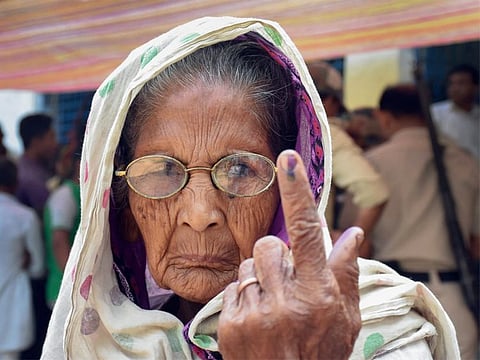 An elderly woman shows her inked marked finger after casting vote in Murshidabad.