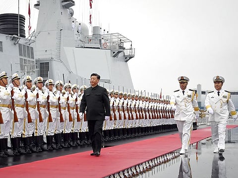 Chinese President Xi Jinping reviews an honor guard before boarding the destroyer Xining at a pier in Qingdao, east China's Shandong Province.