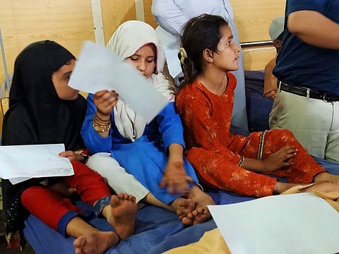 In this picture taken on April 22, 2019, Pakistani children sit on a hospital bed as they are admitted following rumours of reaction after receiving a polio vaccination, in Peshawar.