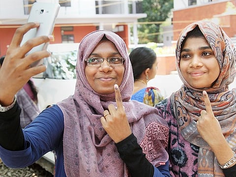 Young voters take a selfie as they pose with their fingers marked with indelible ink at a polling station after casting votes for the third phase of Lok Sabha elections, in Kozhikode, Kerala, on Tuesday, April 23, 2019.