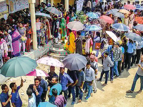 Voters wait in long queues to cast their votes at a polling station, during the third phase of the Lok Sabha polls, in Guwahati on Tuesday.