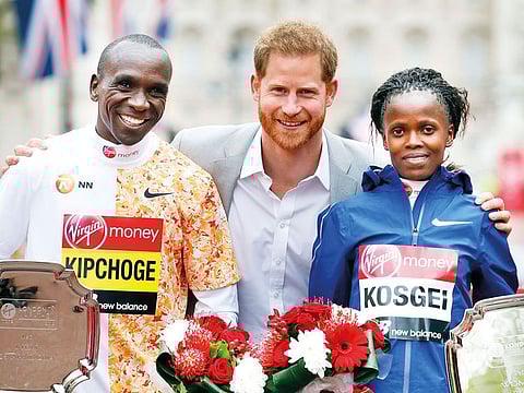 Britain's Prince Harry, centre, poses with the winners of the 39th London Marathon, Kenya's Eliud Kipchoge who won the men's race, left, with Kenya's Brigid Kosgei who won the women's after the presentation ceremony in London, Sunday, April 28, 2019.