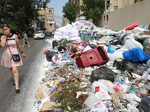 A woman passes a block-long pile of trash in Beirut. Lebanese complain that their politicians are uninterested in the welfare of the people.