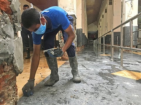 A Sri Lankan Naval soldier picks up the small pieces of glass from inside of the damaged St. Anthony's Church in Colombo, Saturday, April 27, 2019. The archbishop of Colombo Cardinal Malcolm Ranjith said that there will be no Sunday Masses until further notice after the Easter bombings in Sri Lanka..