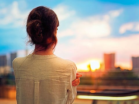 Young girl is watching sunset over Tokyo in Odaiba.