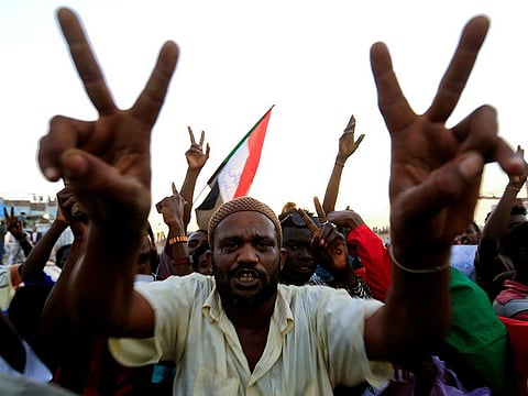 A Sudanese demonstrator from the Darfur region flashes a V-sign and chants slogans as he arrives to be part of a mass anti-government protest outside Defence Ministry in Khartoum, Sudan