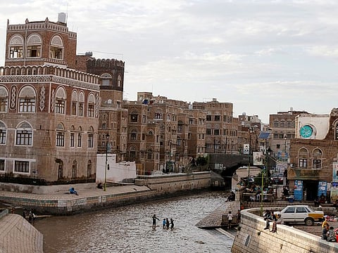 Boys play on a floodway following heavy rains in the old quarter of Sanaa