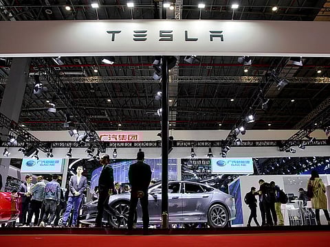 People visit a Tesla booth during the media day for the Shanghai auto show in Shanghai, China.