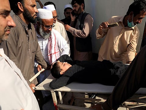 People move a child on a stretcher after what they say was a defective vaccine administered outside a hospital in Peshawar, Pakistan.