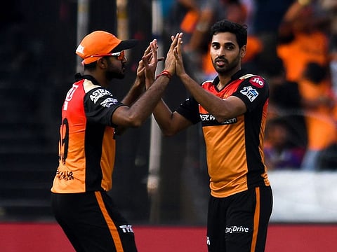 Sunrisers Hyderabad cricketer Bhuvneshwar Kumar (R) celebrates with teammate Vijay Shankar after taking the wicket of Kolkata Knight Riders batsman Andre Russell.