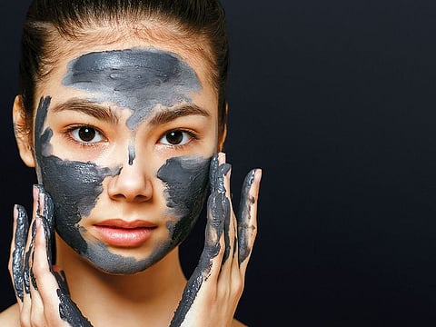 A woman applying beauty mask.