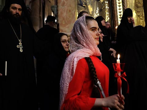 An Orthodox pilgrim holds a candle during the Easter Sunday mass at the Church of the Holy Sepulchre in Jerusalem's Old City on April 28, 2019, as Orthodox Christians celebrate the resurrection of Jesus.