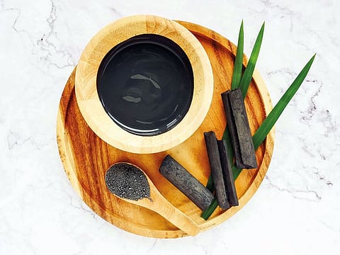 Facial mask and scrub by activated charcoal powder on marble table