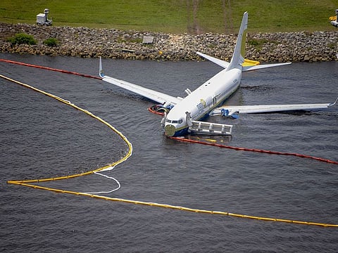 Containment and absorbent booms surround a Boeing 737 aircraft in the St. Johns River after the aircraft slid off the runway at Naval Air Station, Jacksonville, Florida, US, May 4, 2019