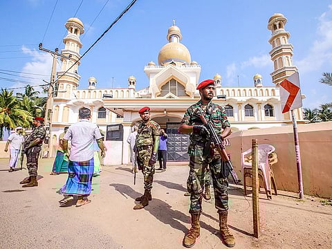 Sri Lankan security personnel stand guard after clashes erupted between Christian and Muslim communities in Negombo on May 6, 2019.