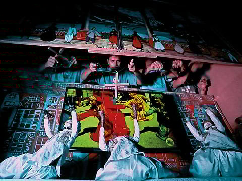 Artists play string puppets during a show in a puppet theatre in Karachi.