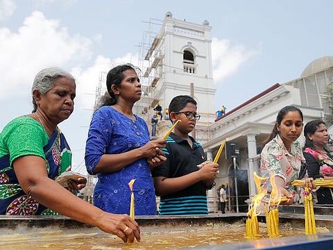 Sri Lankan Catholic devotees light candles outside the St. Anthony's church after it was partially opened for the first time since Easter Sunday attacks, in Colombo, Sri Lanka, Tuesday, May 7, 2019.