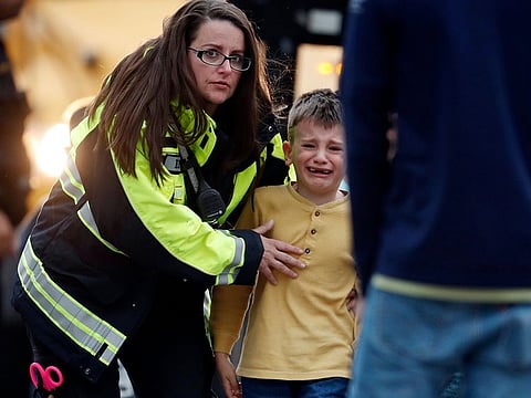 Officials guide students off a bus and into a recreation center where they were reunited with their parents after a shooting at a suburban Denver middle school Tuesday, May 7, 2019, in Highlands Ranch, Colorado.