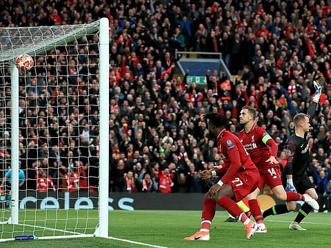 Liverpool's Divock Origi, left, scores his side's first goal of the game during the Champions League Semi Final, second leg soccer match between Liverpool and Barcelona at Anfield, Liverpool, England, Tuesday, May 7, 2019.