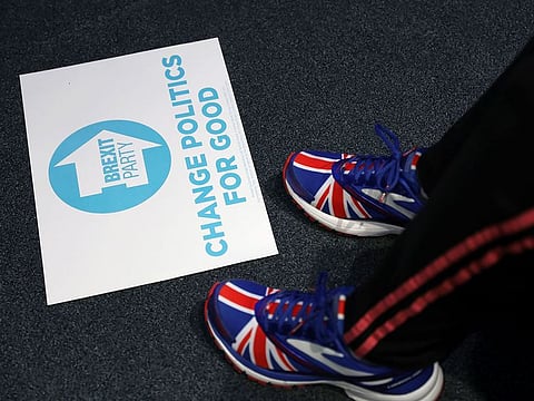 A placard is put on the floor between a person's shoes with the Union Jack on it, inside Kings Gate Conference Centre before the start of a rally held by Brexit Party leader Nigel Farage and former Conservative Party MP Ann Widdecombe in Peterborough, Britain May 7, 2019.