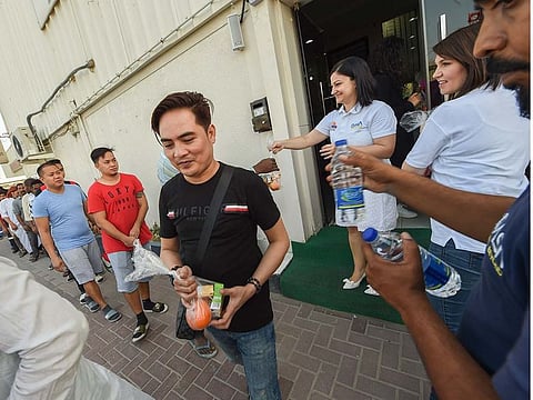 All smiles as workers pick up food packets from a fridge point in Al Quoz