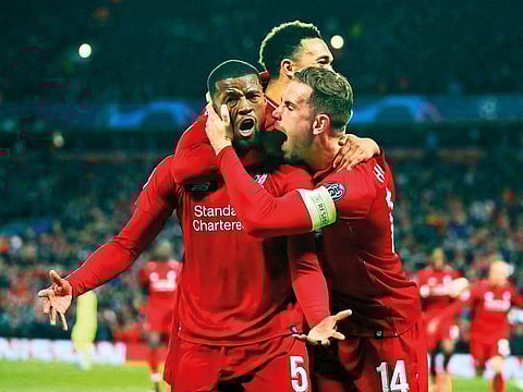 Liverpool's Georginio Wijnaldum, left, celebrates scoring his side's third goal of the game during the Champions League Semi Final, second leg soccer match between Liverpool and Barcelona at Anfield, Liverpool, England, Tuesday, May 7, 2019.