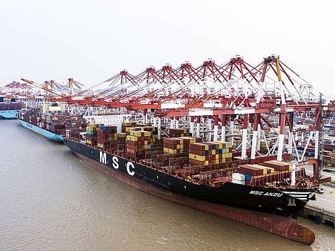 The Mediterranean Shipping Co. (MSC) Anzu container ship, front, is docked next to gantry cranes at the Yangshan Deepwater Port, operated by Shanghai International Port Group Co. (SIPG), in this aerial photograph taken in Shanghai, China, on Friday, May 10, 2019.