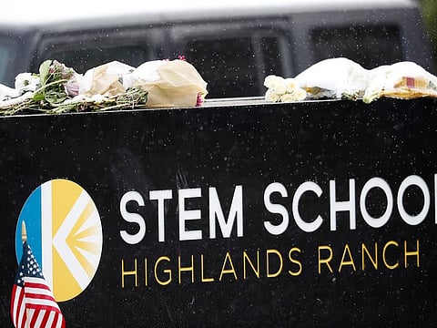 A light snow covers bouquets of flowers placed on the sign for STEM School Highlands Ranch following Tuesday's shooting, in Highlands Ranch, Colo., Thursday, May 9, 2019.