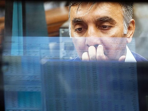 A stockbroker looks at share prices on a computer monitor during a trading session at the Pakistan Stock Exchange (PSX) in Karachi. Analysts have warned that any fresh IMF deal could come with restrictions that would hobble Prime Minister Imran Khan's grand promises to build an Islamic welfare state.
