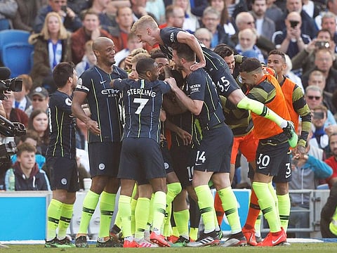 Manchester City players celebrate their third goal during the English Premier League soccer match against Brighton at the AMEX Stadium in Brighton.