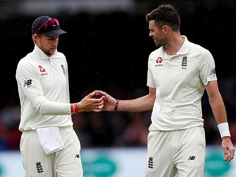 England's Joe Root gives the ball to James Anderson.