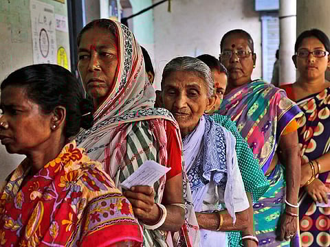 Indian women stand in queue to cast their votes at a polling booth in Bardhaman east constituency, West Bengal state, India.