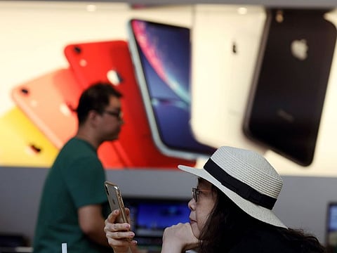 A customer looks at her iPhone in a store of US tech company Apple in Beijing.