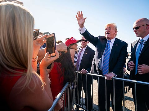 President Donald Trump greets supporters as he arrives at Louis Armstrong New Orleans International Airport in Kenner.