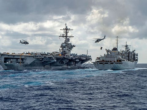 This handout picture released by the US Navy on May 8, 2019 shows the Nimitz-class aircraft carrier USS Abraham Lincoln (CVN 72) while conducting a replenishment-at-sea with the fast combat support ship USNS Arctic (T-AOE 9), while MH-60S Sea Hawk helicopters assigned to the "Nightdippers" of Helicopter Maritime Strike Squadron (HSM) 5, transfer stores between the ships. The US is deploying an amphibious assault ship and a Patriot missile battery to bolster an aircraft carrier and B-52 bombers already sent to the Gulf, ratcheting up pressure on Iran. The USS Arlington, which transports marines, amphibious vehicles, conventional landing craft and rotary aircraft, and the Patriot air defence system will join the Abraham Lincoln carrier group, the Pentagon announced on May 10.