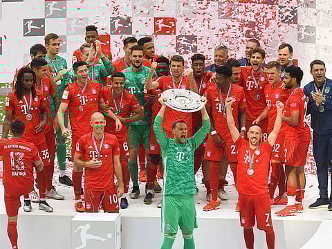 Bayern Munich's goalkeeper Manuel Neuer lifts the trophy as Bayern Munich players celebrate after the German First division Bundesliga football match FC Bayern Munich v Eintracht Frankfurt in Munich, southern Germany, on May 18, 2019.