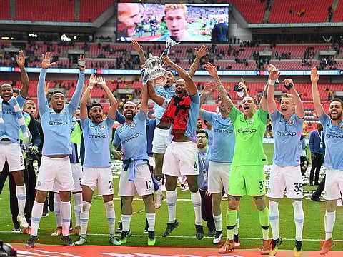 Manchester City's Belgian defender Vincent Kompany (C) lifts the winner's trophy as the team celebrates victory after the English FA Cup final football match between Manchester City and Watford at Wembley Stadium in London, on May 18, 2019.
